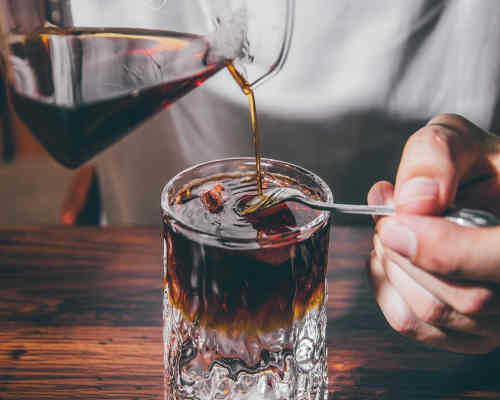 Double Dirty Detroit Drink: A bold and intensified version of the classic Dirty Detroit cocktail, made with bourbon, maple syrup, lemon juice, and Angostura bitters, served in a rock glass with a smoked salt rim.